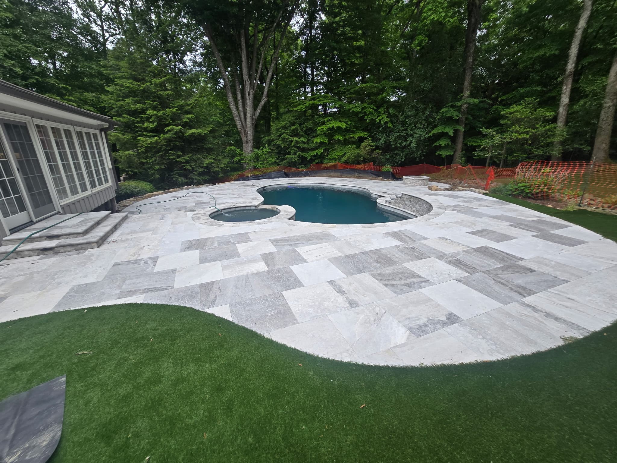 Luxury freeform shotcrete pool with integrated spa and travertine deck