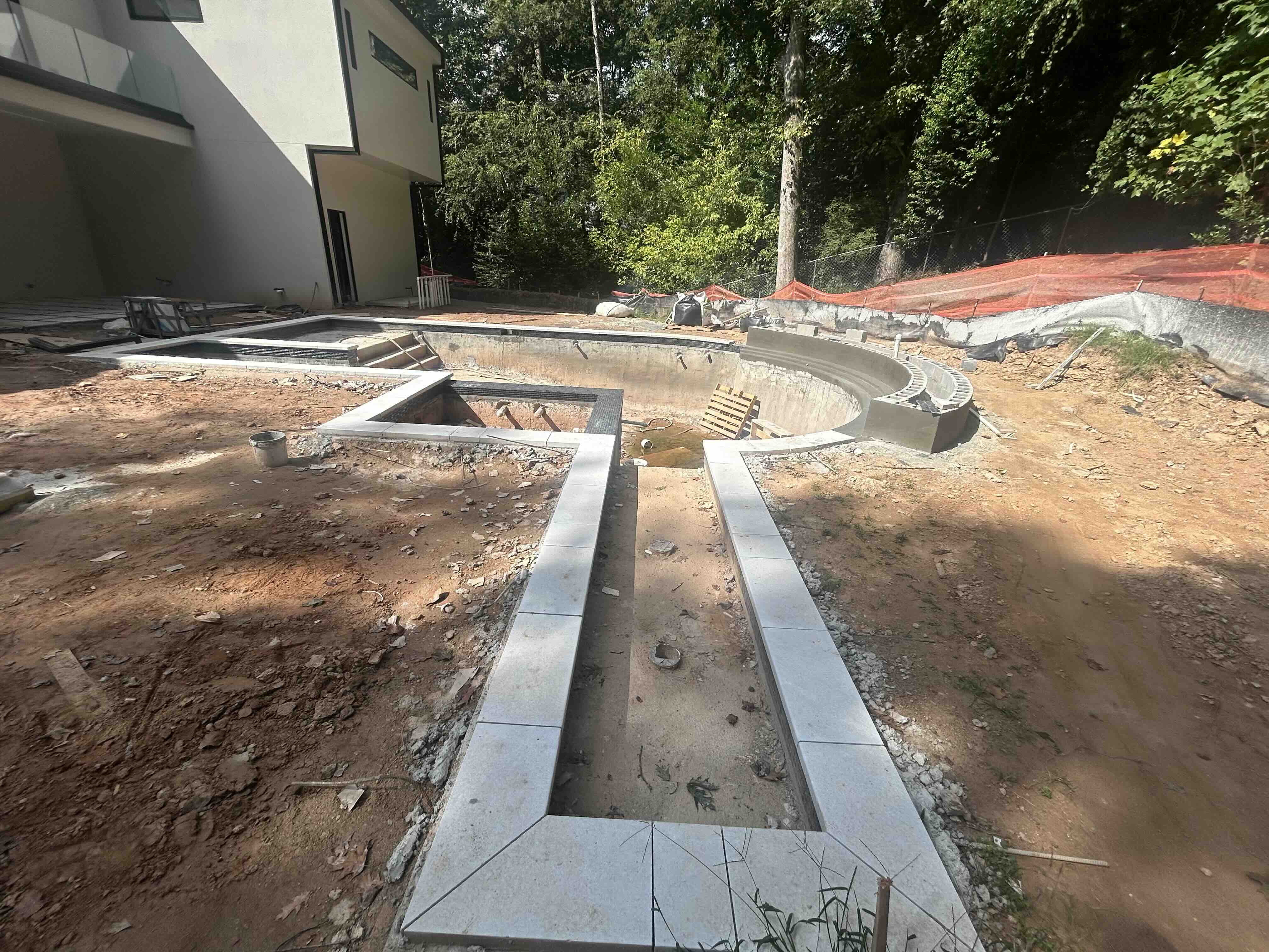 Curved bench walls and coping stones installed on a custom pool build in Atlanta
