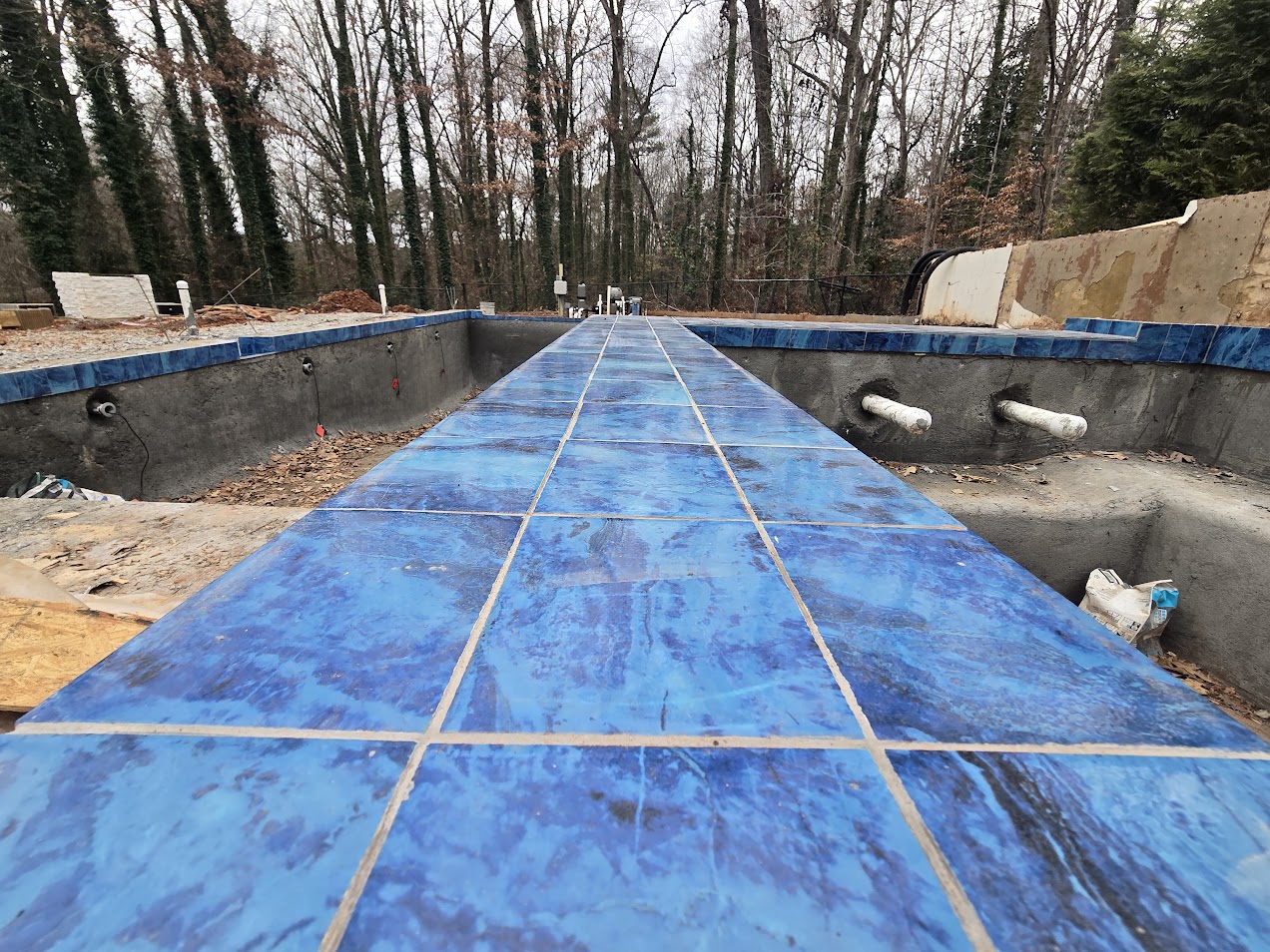 Blue waterline tile installation on shotcrete pool