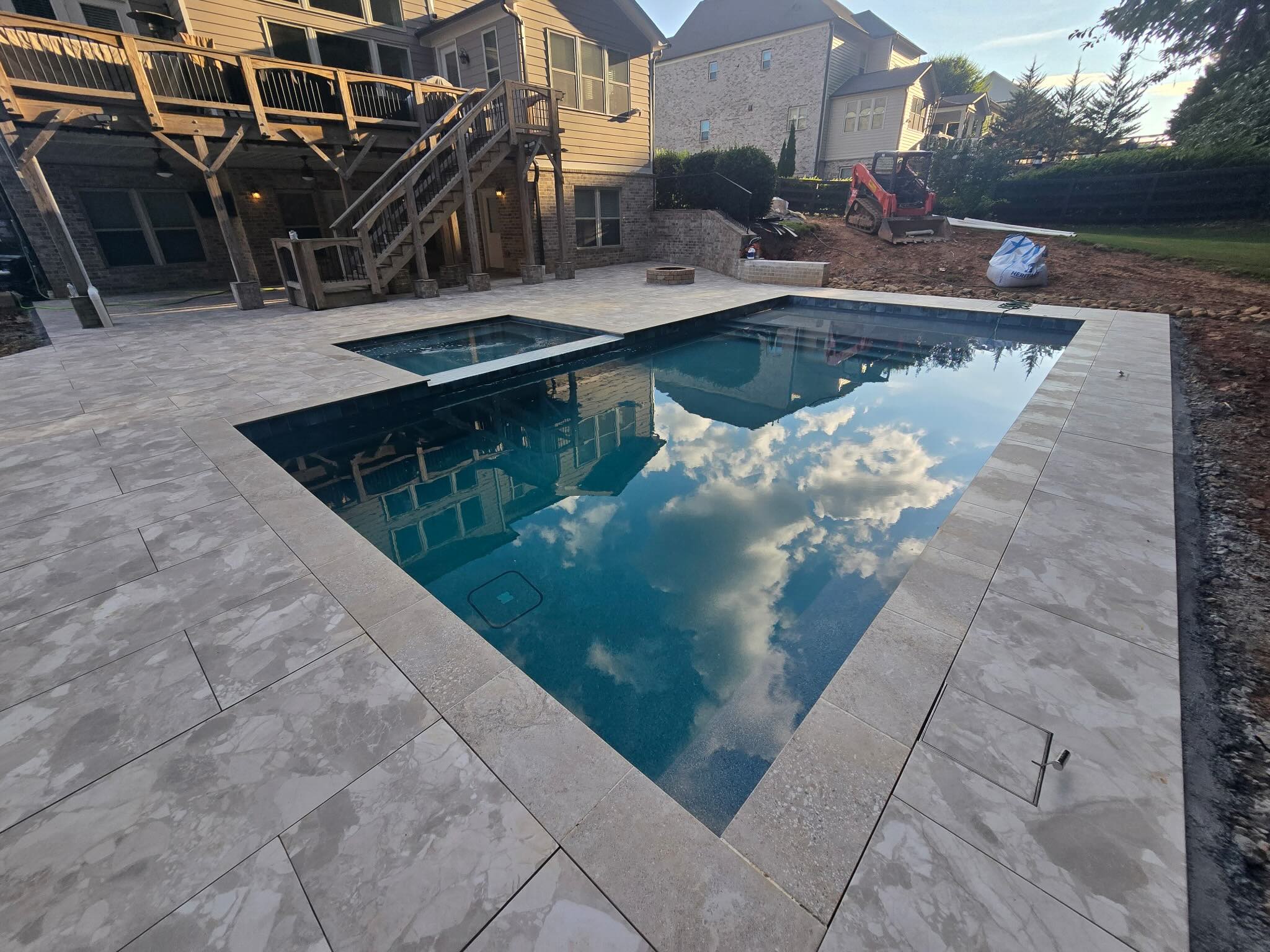 Aerial view of a finished shotcrete pool with dark pebble finish and travertine deck in Milton, Georgia