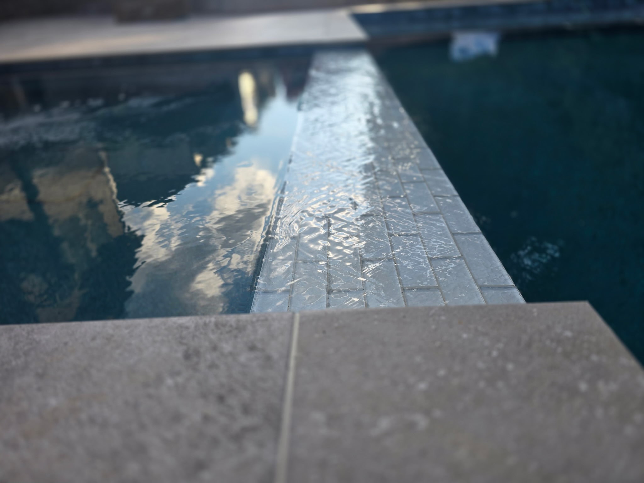 Glass tile spa spillway sheeting water into a shotcrete pool in Milton, Georgia
