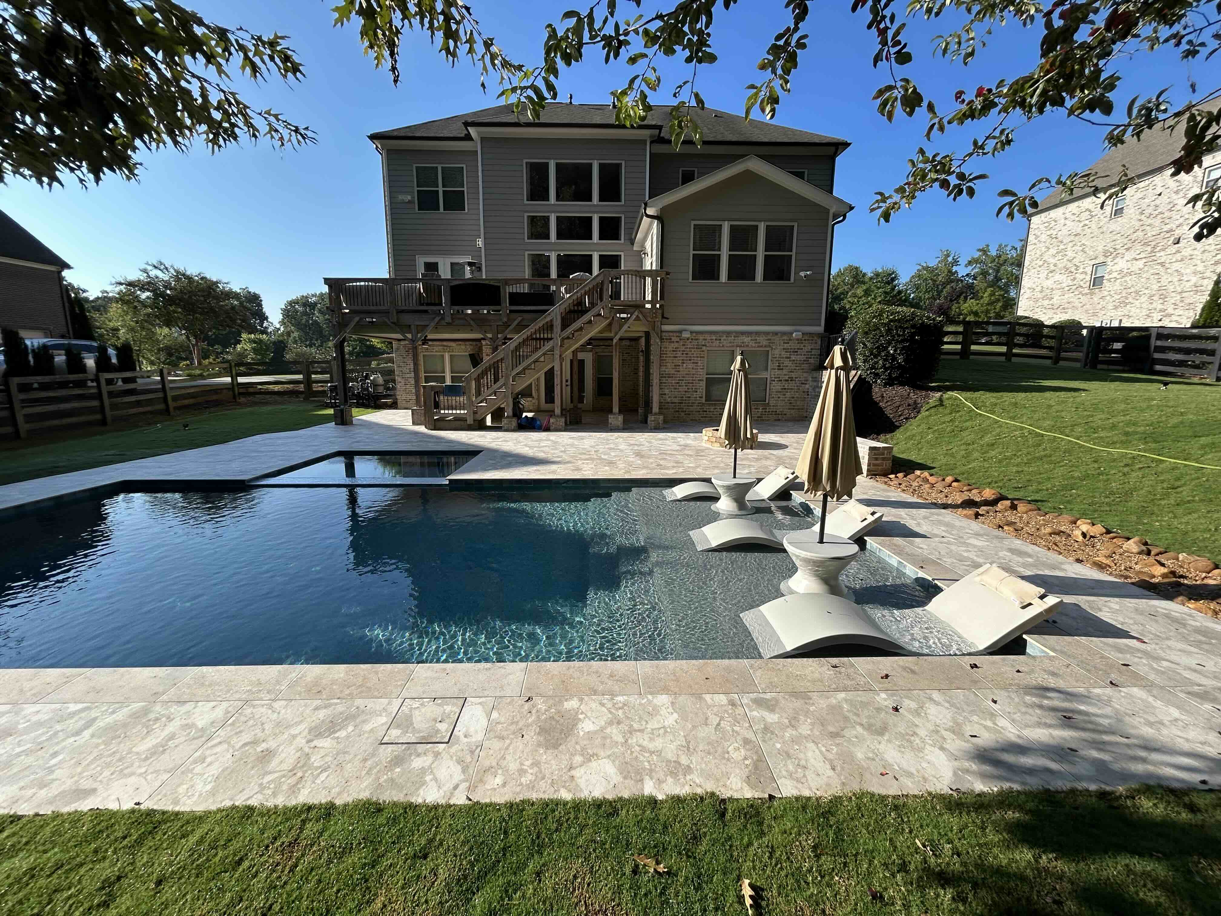 Backyard pool with travertine decking and in-water loungers in Metro Atlanta